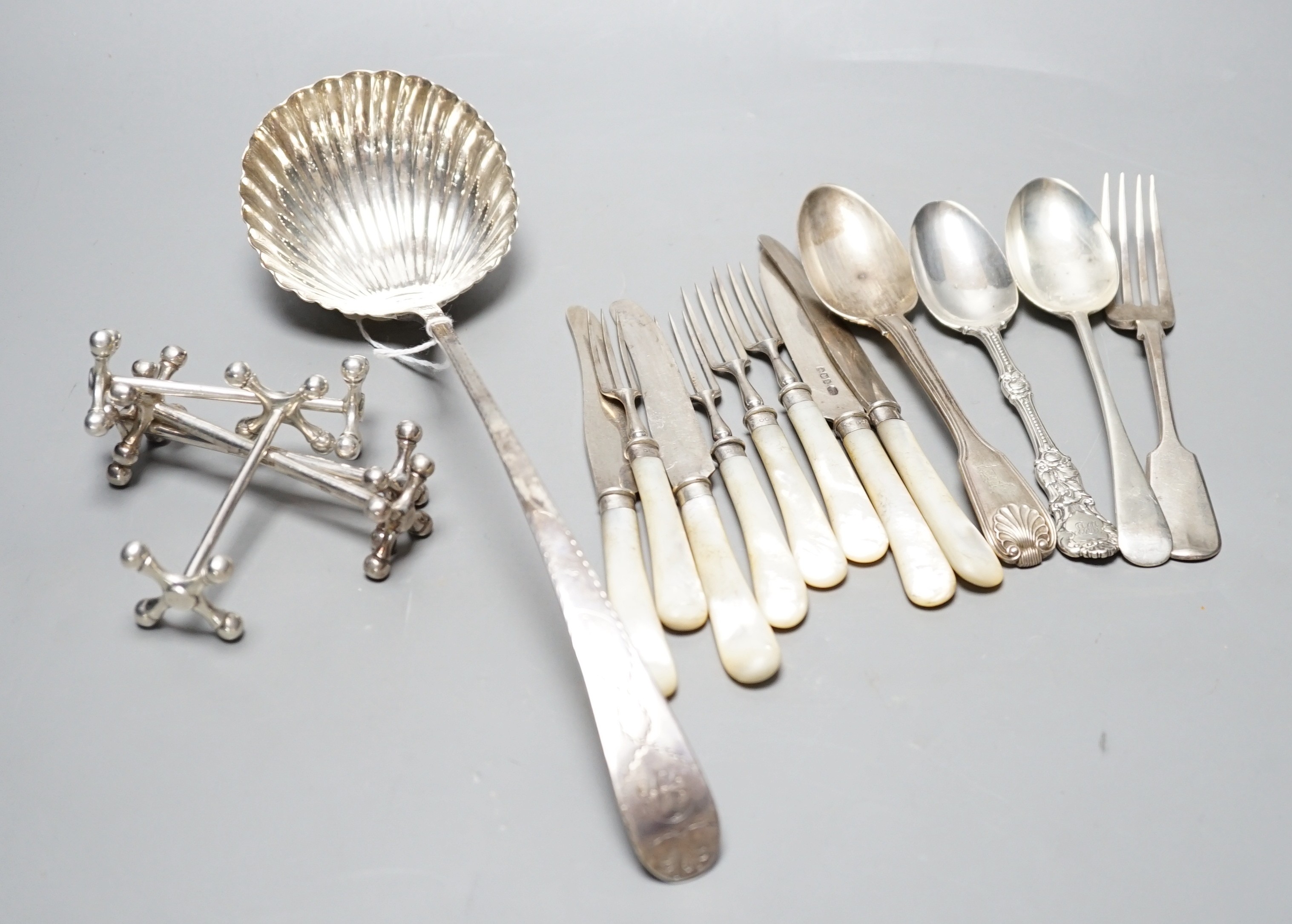 An 18th century silver Old English pattern soup ladle, marks rubbed,(a.f.), two pairs of silver knife rests including Mappin & Webb, Sheffield, 1915 and twelve other items of flatware.